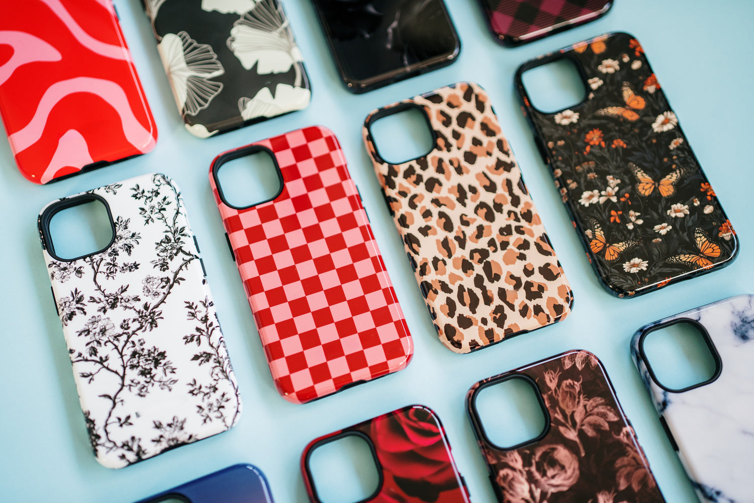 Flat image of high fashion phone cases featuring floral phone cases, red checkerboard phone case, leopard print phone case, and abstract phone cases - aesthetic cases for iPhone, Samsung Galaxy, and Google Pixel