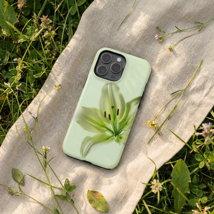 iPhone 15 pro case with a green floral design sitting on a fabric surface surrounded by grass and flowers