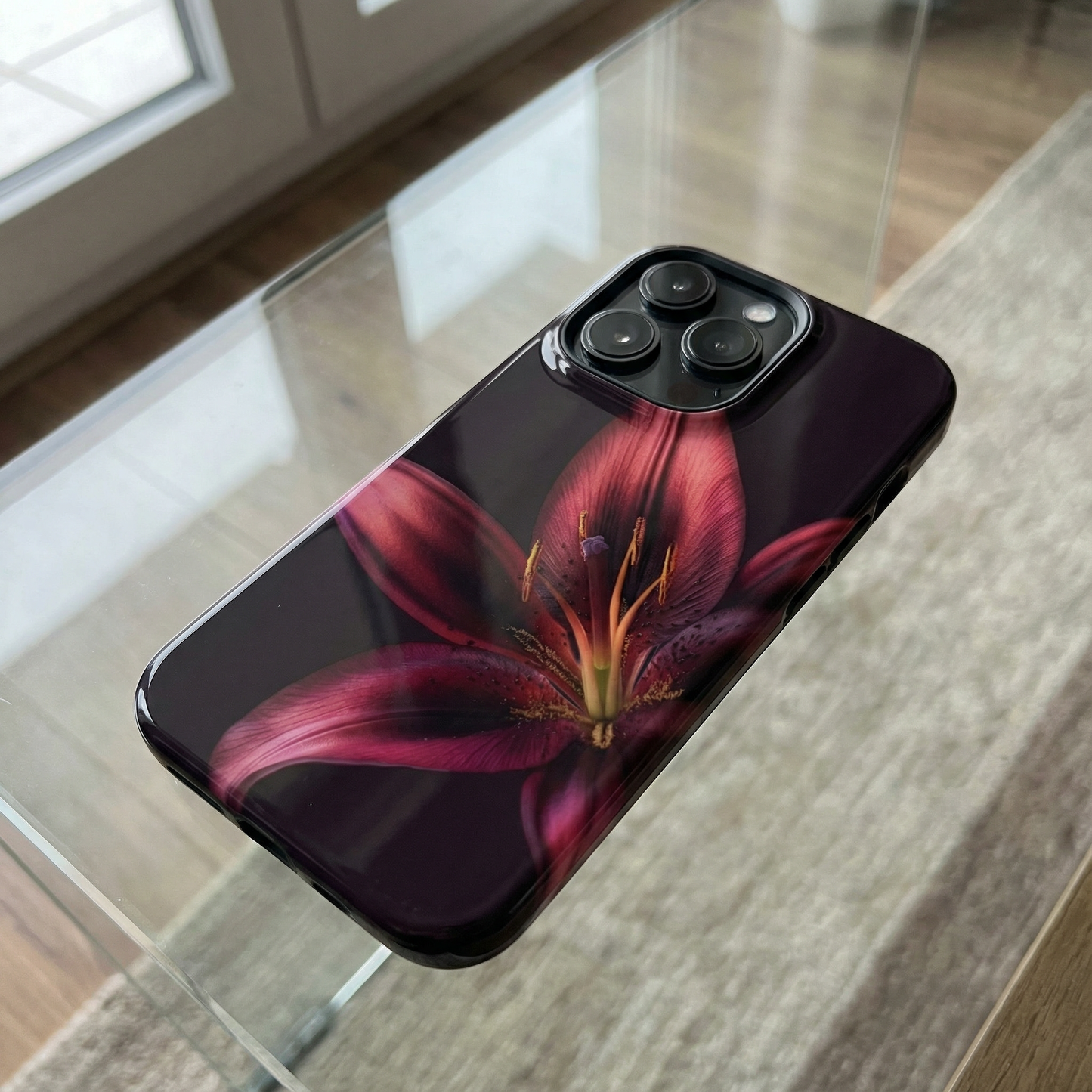 Phone case with a purple flower design sitting on a glass table