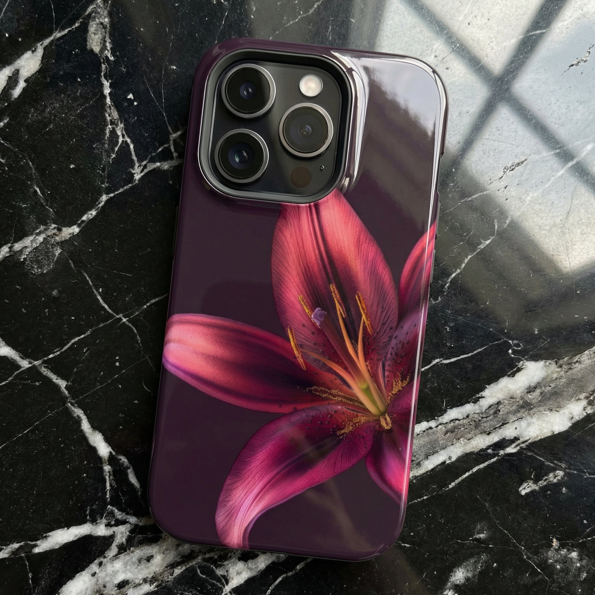 iPhone case with a purple flower design on a black marble surface