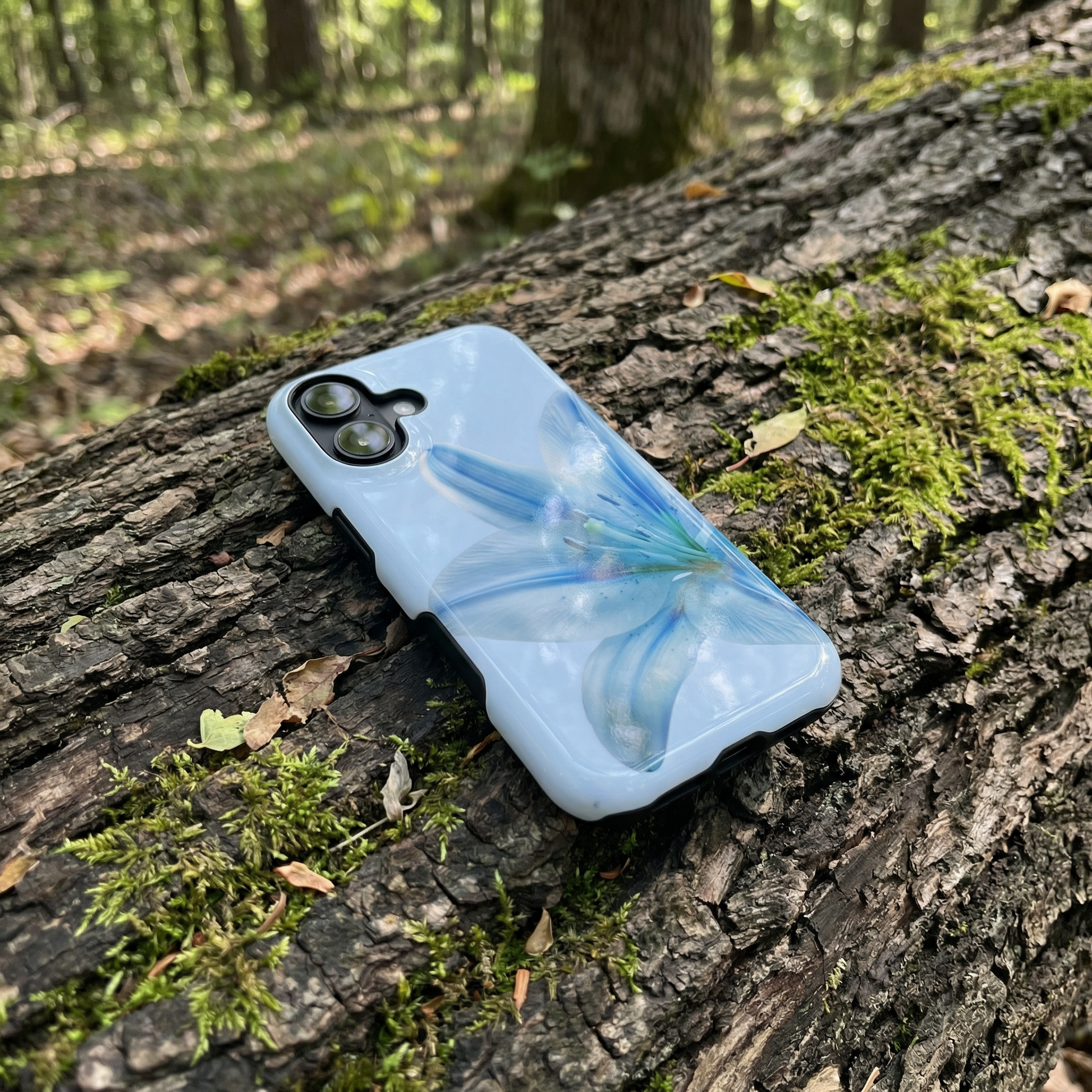 iPhone case with a blue floral phone case on a tree trunk in a forest