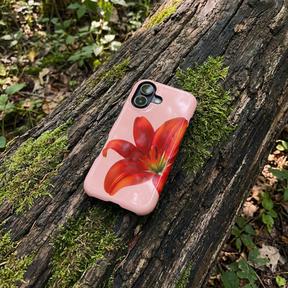 iPhone case with red flower design sitting on a wooden log in a natural setting