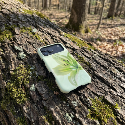 iPhone 17 pro max case with green flower design on a mossy tree trunk in a forest